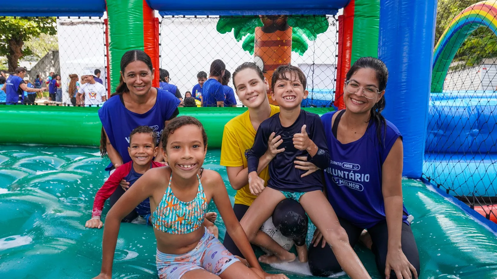 Crianças e voluntárias sorrindo na piscina de espuma durante uma ação da ONG