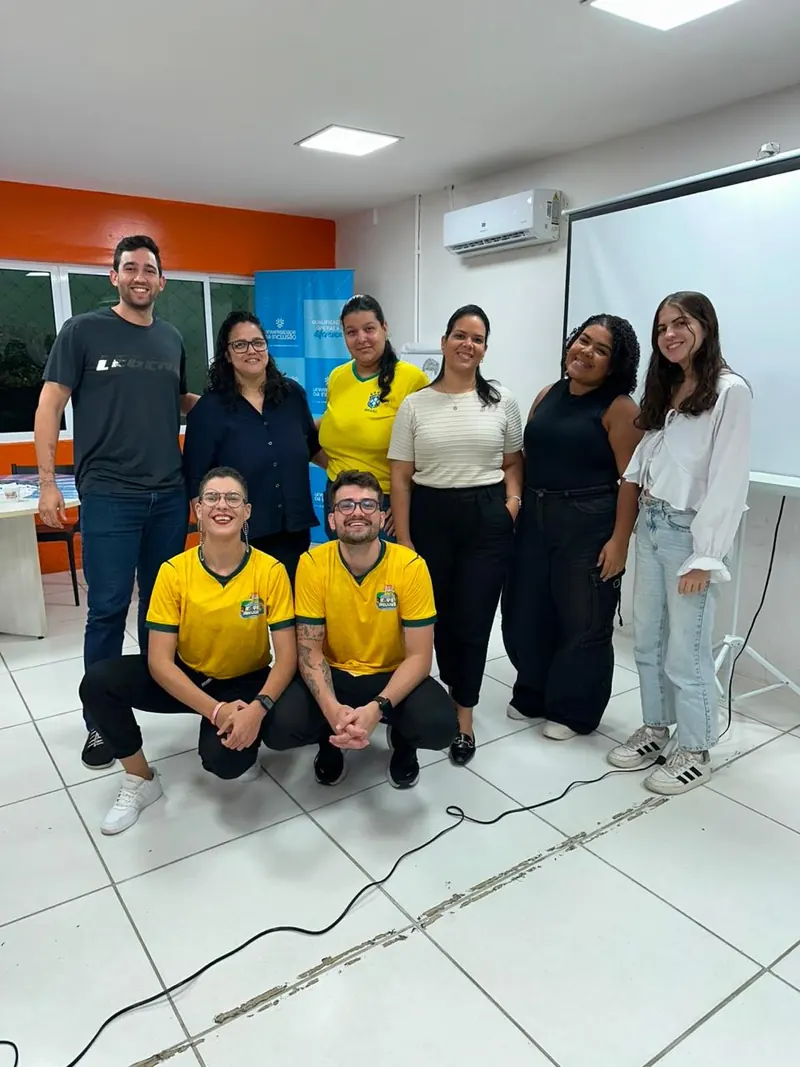 Grupo de sete voluntários reunido ao fim de uma formação do Time da Inclusão